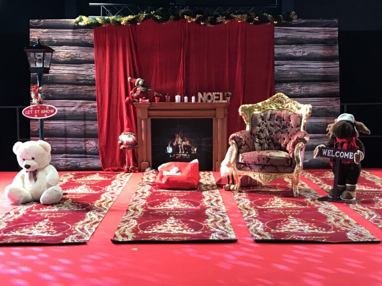 Décor de Noël avec cheminée, fauteuil du Père Noël et ours en peluche pour un arbre de Noël de comité d entreprise