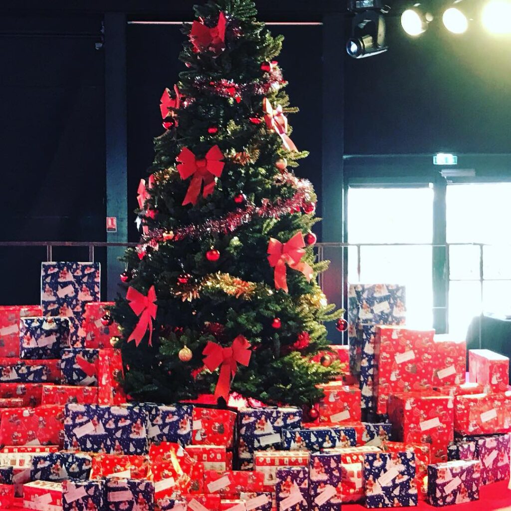 Sapin de Noël décoré entouré de cadeaux emballés pour un arbre de Noël d entreprise