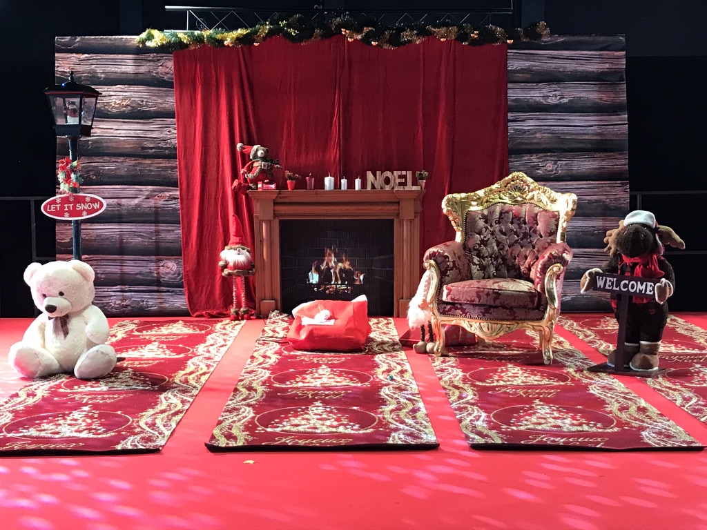 Décor de Noël avec cheminée, fauteuil et lettres lumineuses