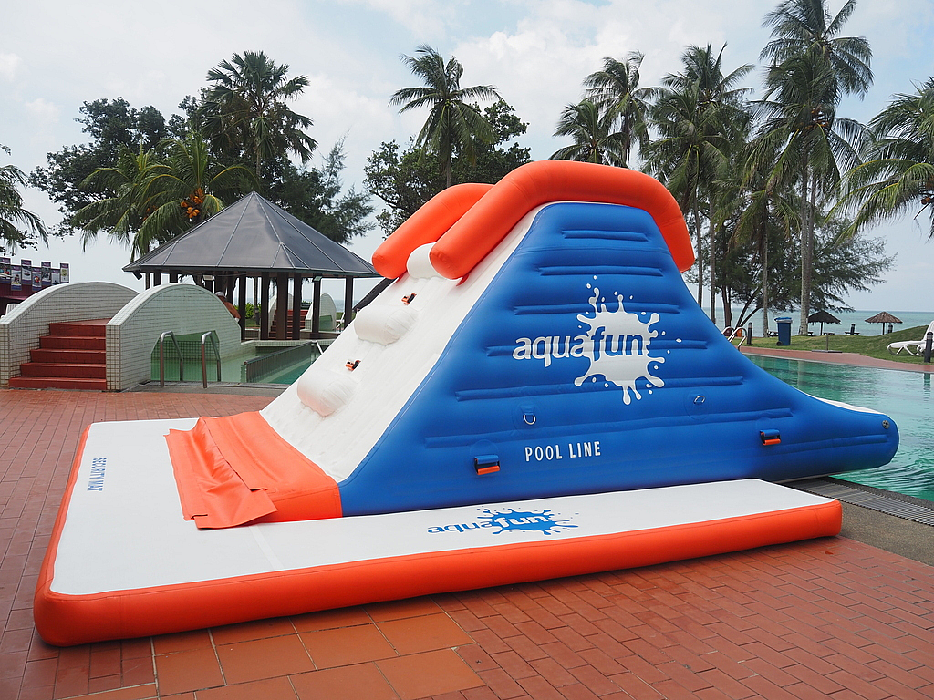 Toboggan gonflable installé au bord d un bassin de piscine